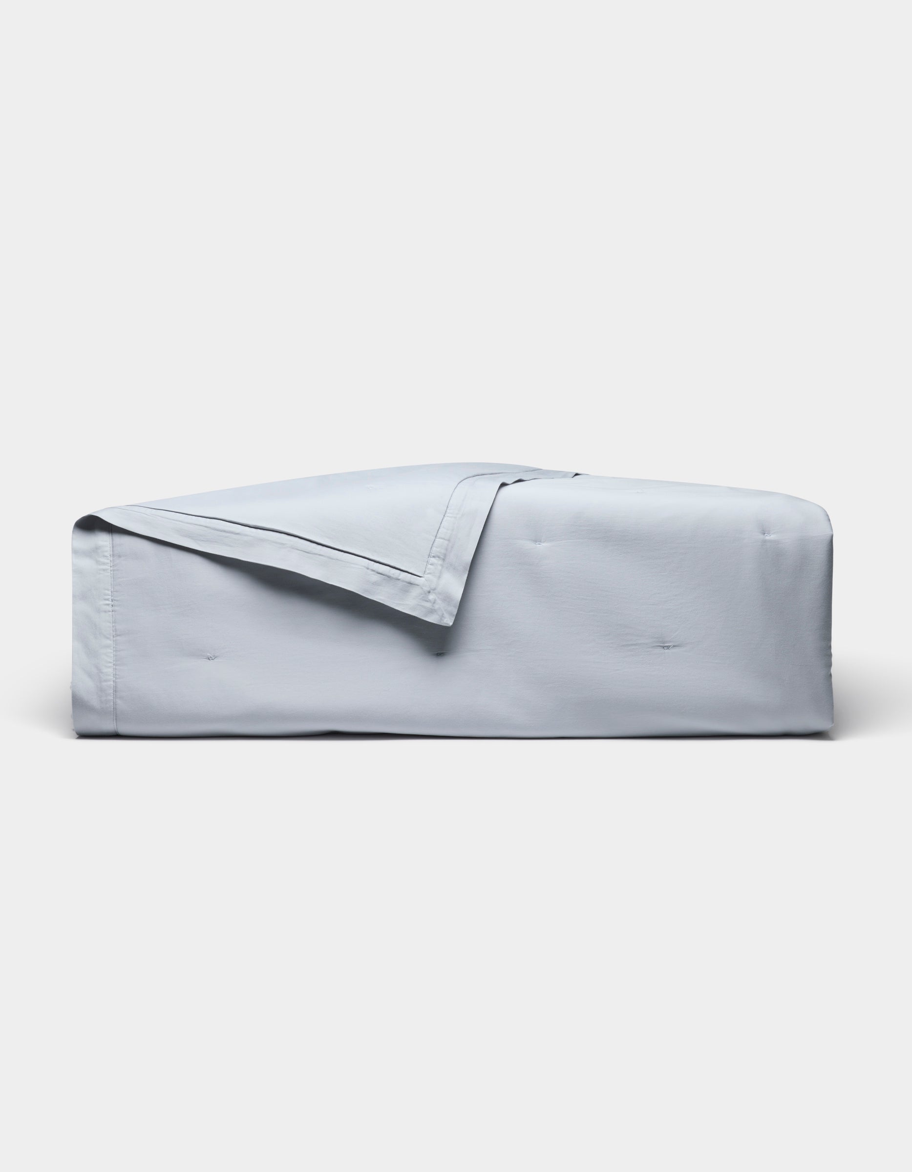The Cozy Earth Soft-Wash Cotton Quilt, in light blue with a matching folded-back corner, is displayed on a plain white background.|Color:Shore