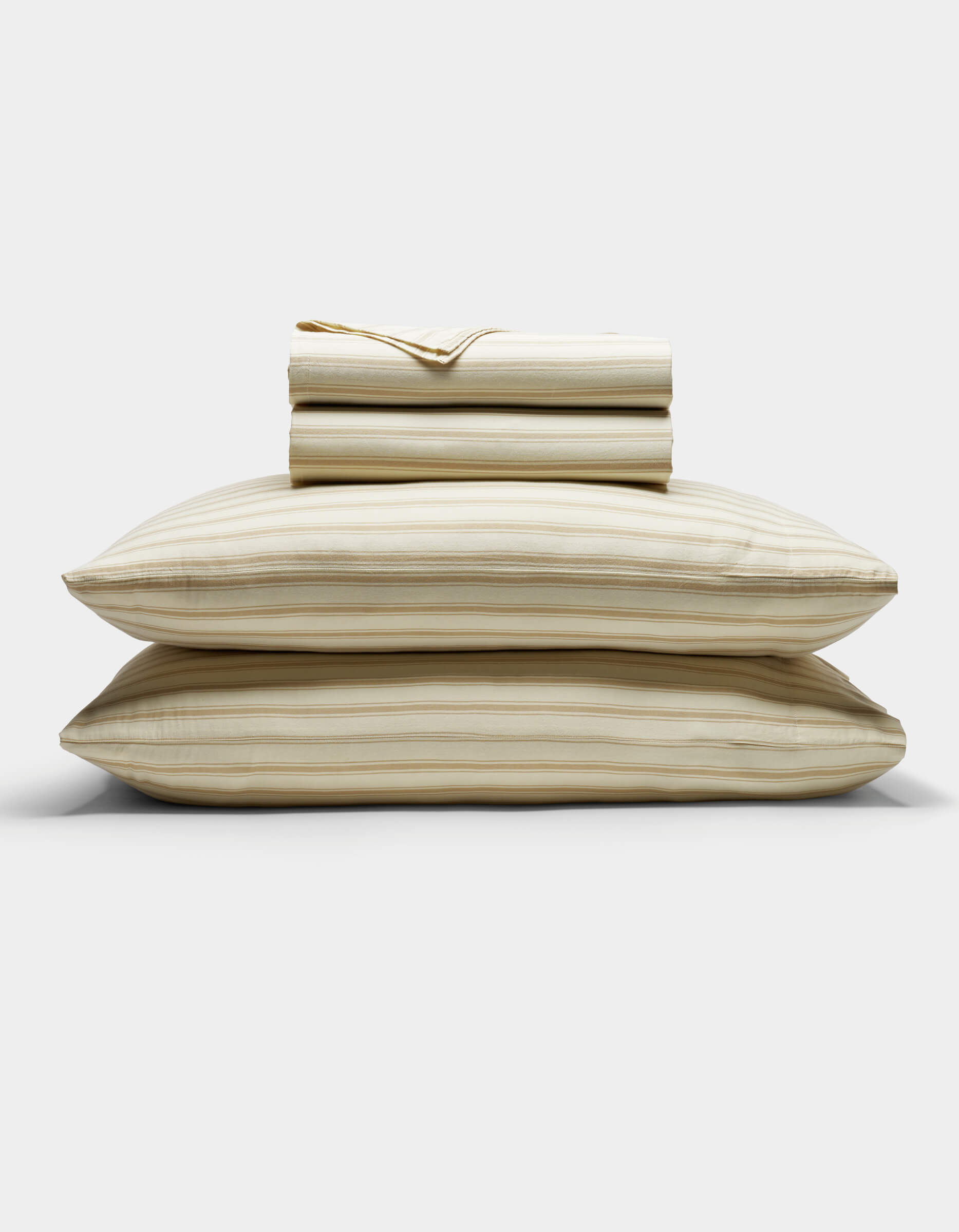 The Cozy Earth Soft-Wash Cotton Sheet Set in beige and light brown stripes is neatly stacked with two pillows at the base, topped with folded sheets and a pillowcase, displayed against a plain white background.|Color:Coconut and Sandalwood Stripe