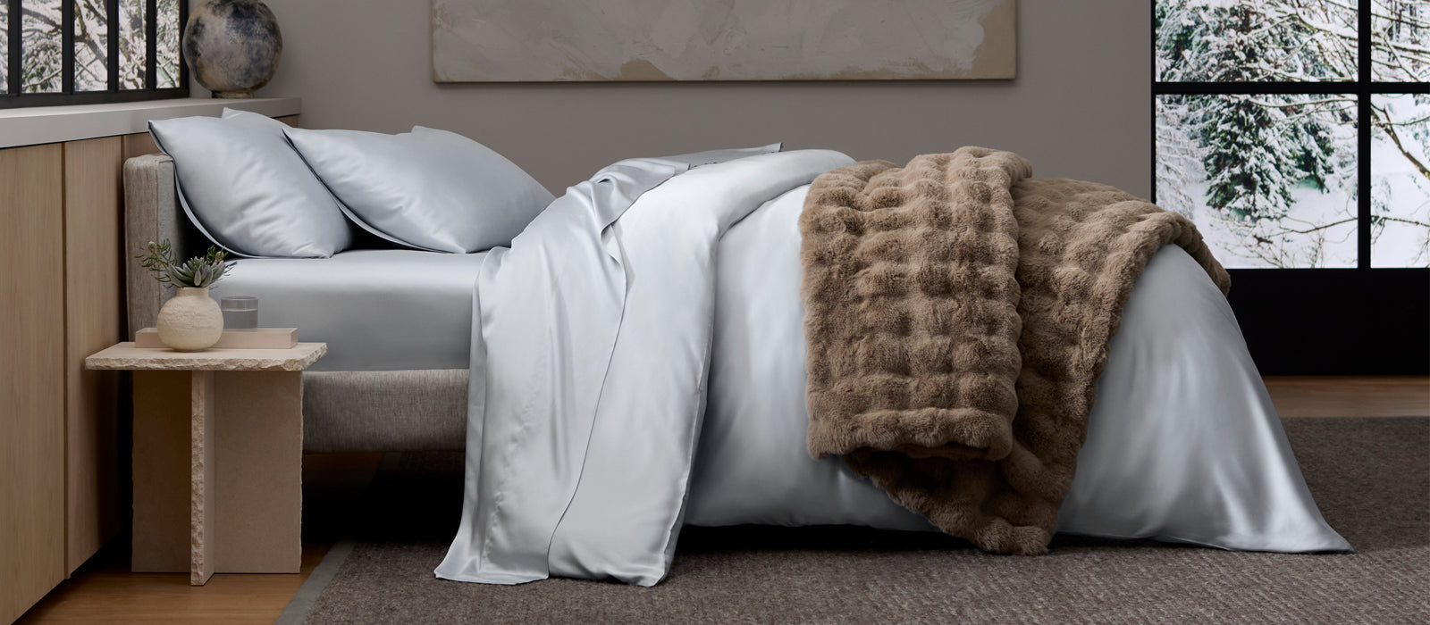 A luxurious bed covered in Cozy Earth Bedding and Bubble Cuddle Blanket.  