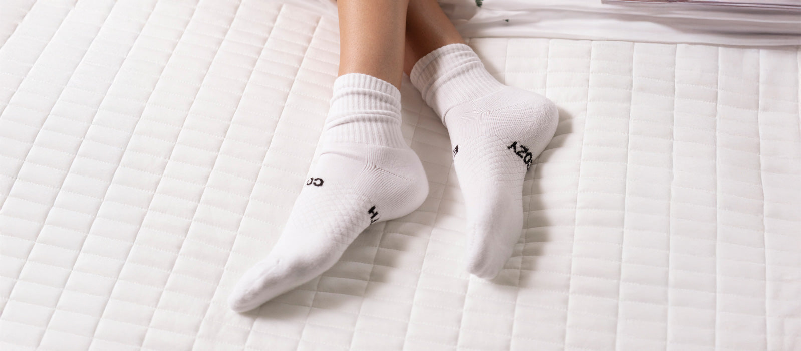 A pair of women's feet featuring Cozy Earth Essential Socks, 