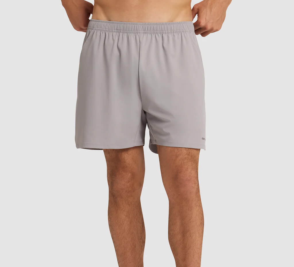 Man wearing light gray shorts on a white background