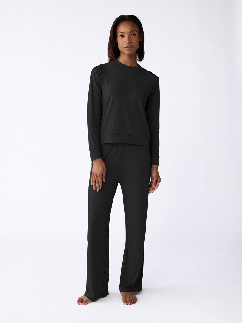 A person is barefoot, wearing the Cozy Earth Women's Ultra-Soft Bamboo Wide Leg Pull On Pant & Pullover Crew Set against a light background.