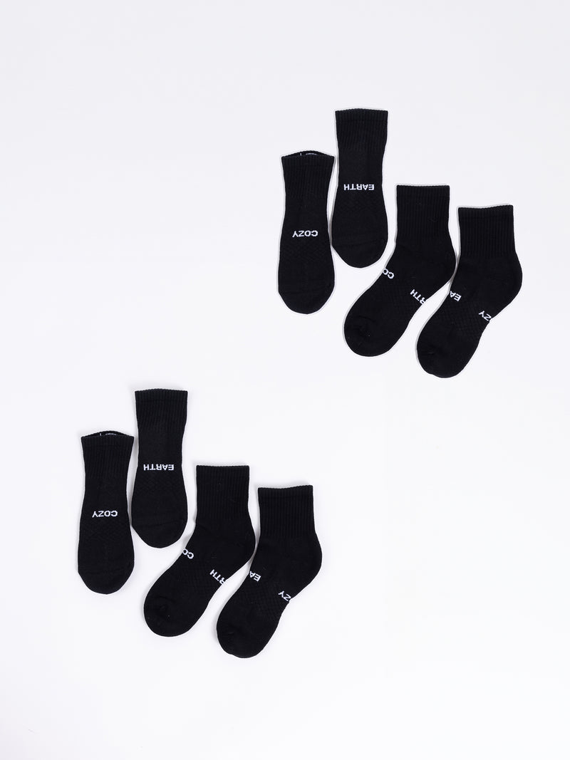 A four-pack of black quarter socks from Cozy Earth, each pair arranged unevenly against a white background. Each sock features the words "COZY EARTH" printed in white near the toes.