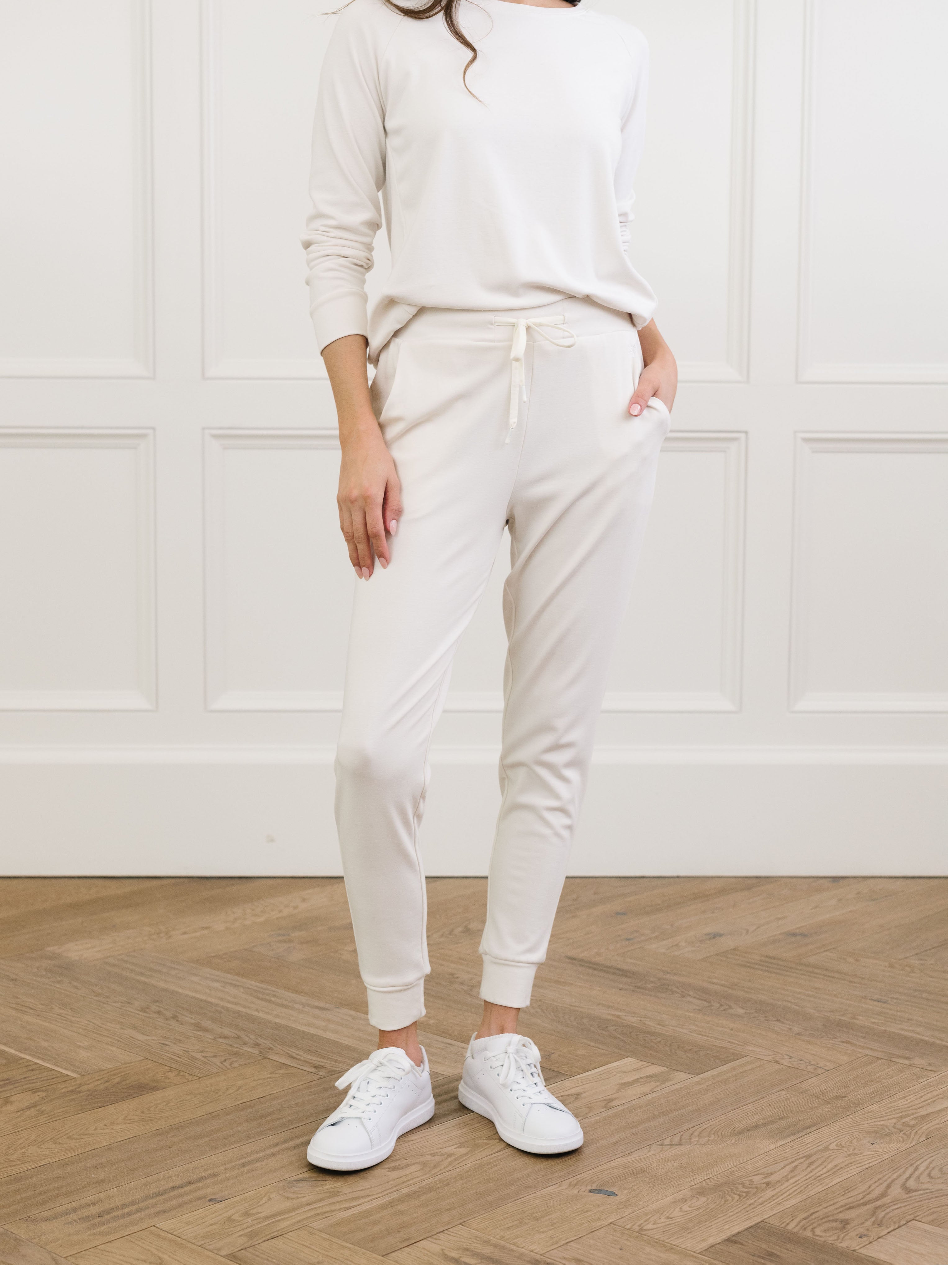 Ivory Bamboo Jogger Set modeled by a woman. The photo was taken in a high contrast setting, showing off the colors and lines of the pajamas. |Color: Ivory