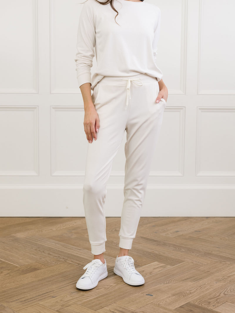 Ivory Bamboo Jogger Set modeled by a woman. The photo was taken in a high contrast setting, showing off the colors and lines of the pajamas.