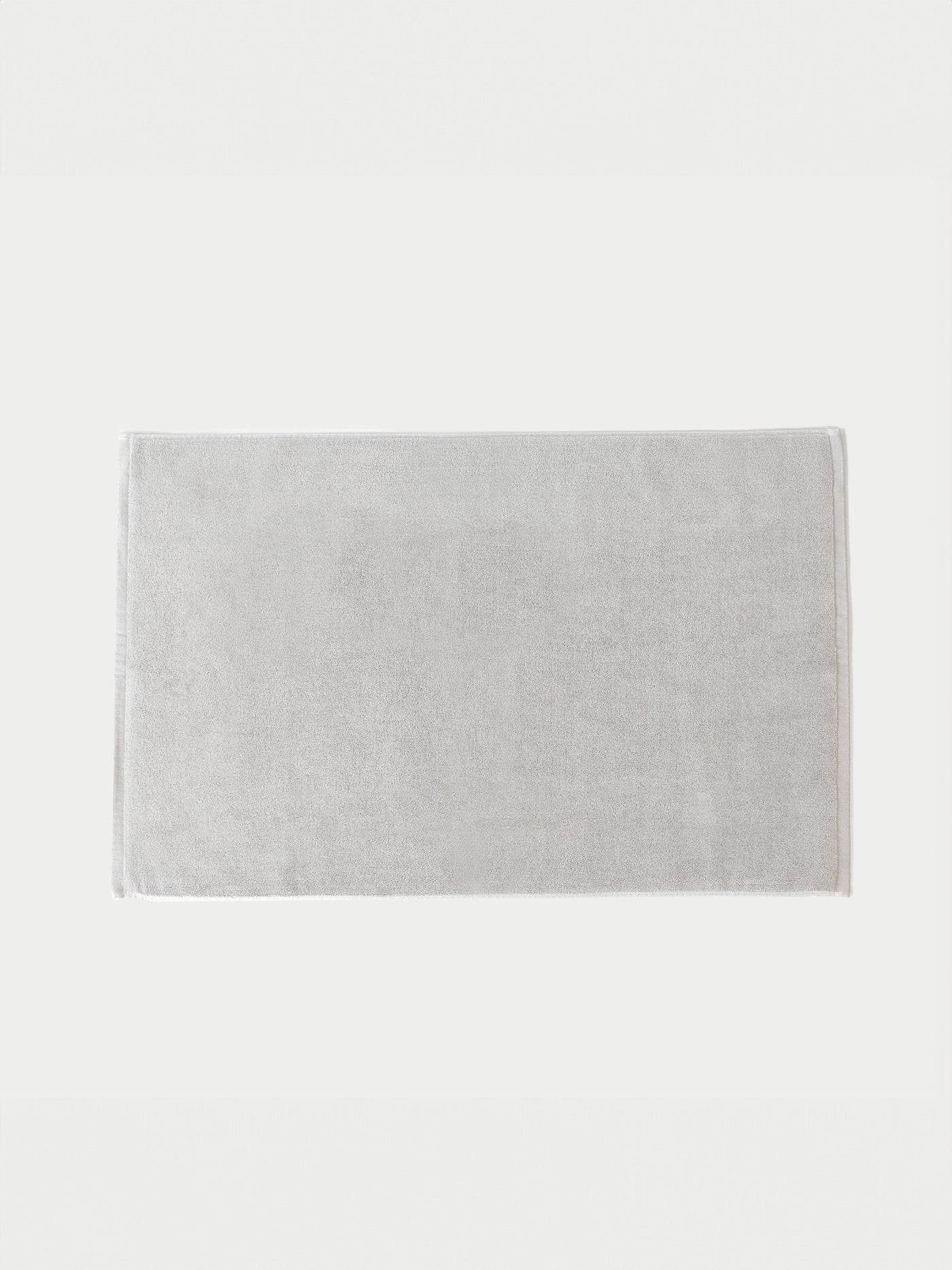 The Cozy Earth Loop Terry Bath Mat features a rectangular, light gray solid design, shown placed on a white background.