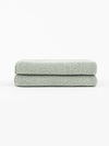 A pair of Nantucket Hand Towels in Heathered Clay is stacked in front of a white background. |Color:Heathered Sage