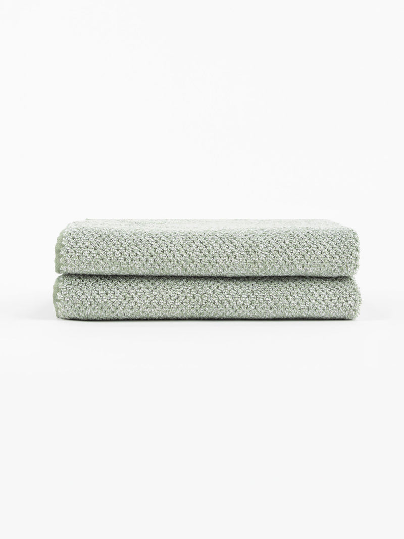 A pair of Nantucket Hand Towels in Heathered Clay is stacked in front of a white background.