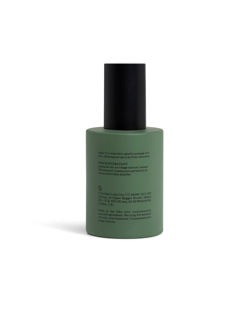 Green Fount Society Body Serum bottle turned backward with black cap on a white background