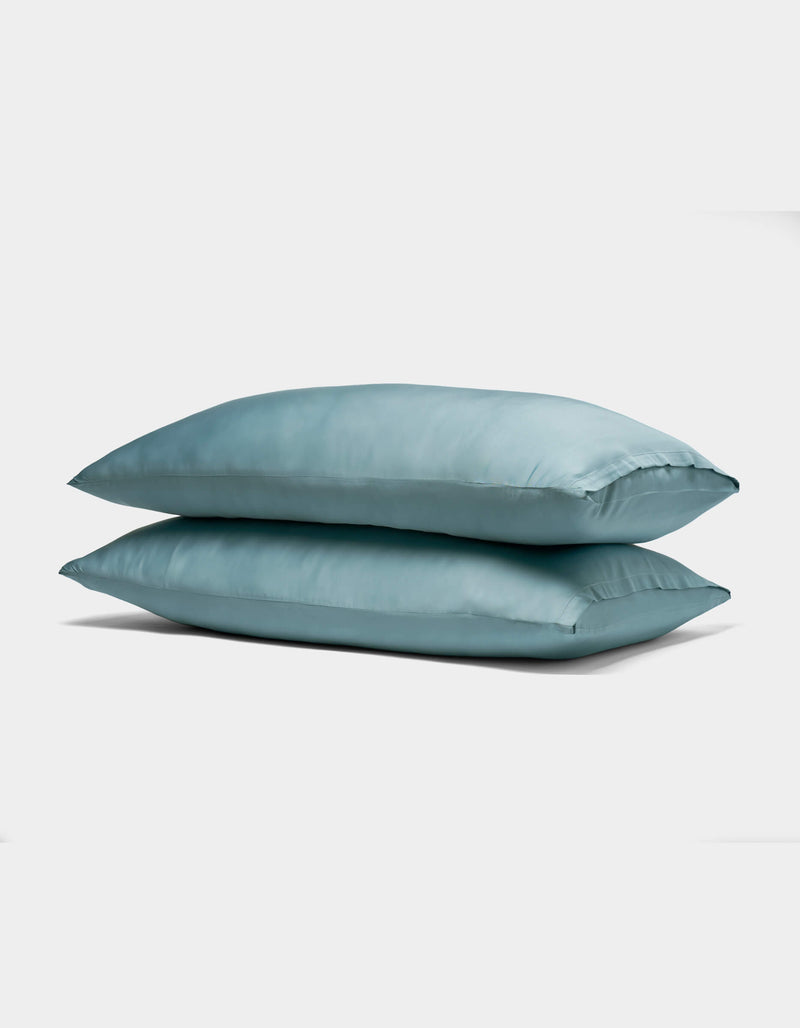 Two Cozy Earth Bamboo Pillowcases in light blue are stacked together against a plain white background.