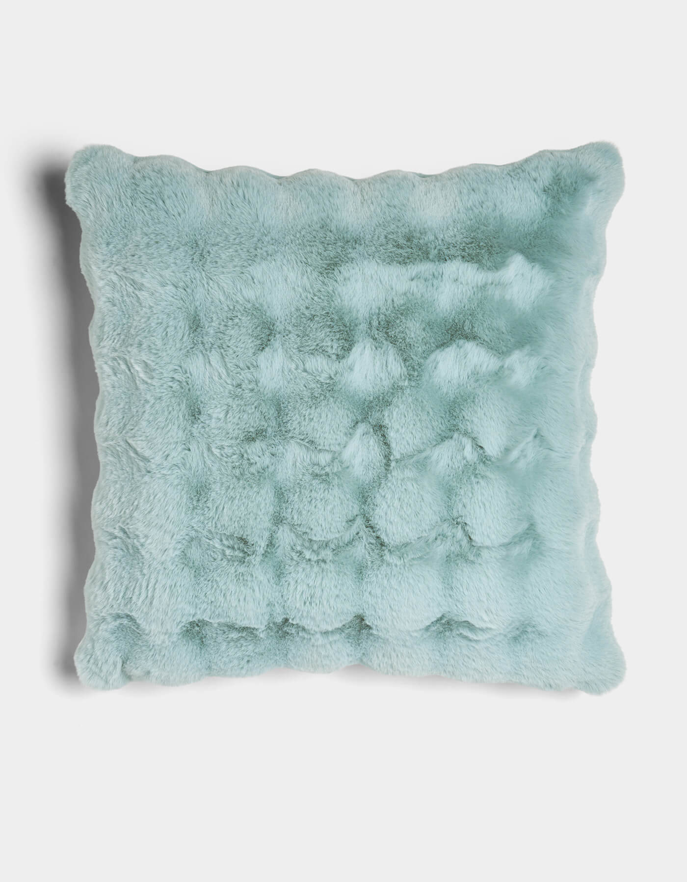 The Bubble Cuddle Pillow by Cozy Earth is a square, light blue faux fur pillow with a plush, textured surface and wavy scalloped edges, shown against a white background.