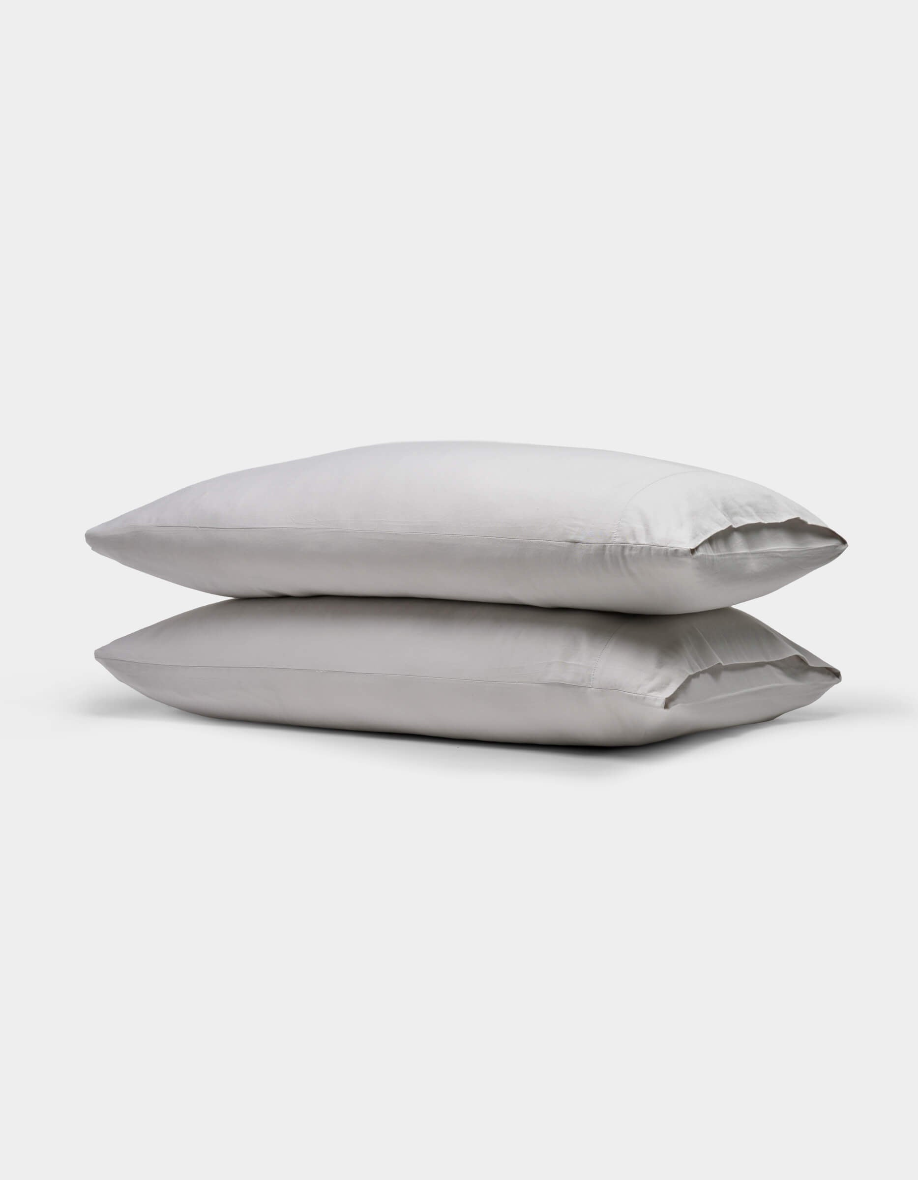 Two stacked, rectangular Soft-Wash Cotton Pillowcases by Cozy Earth in light gray are shown on a plain white background.