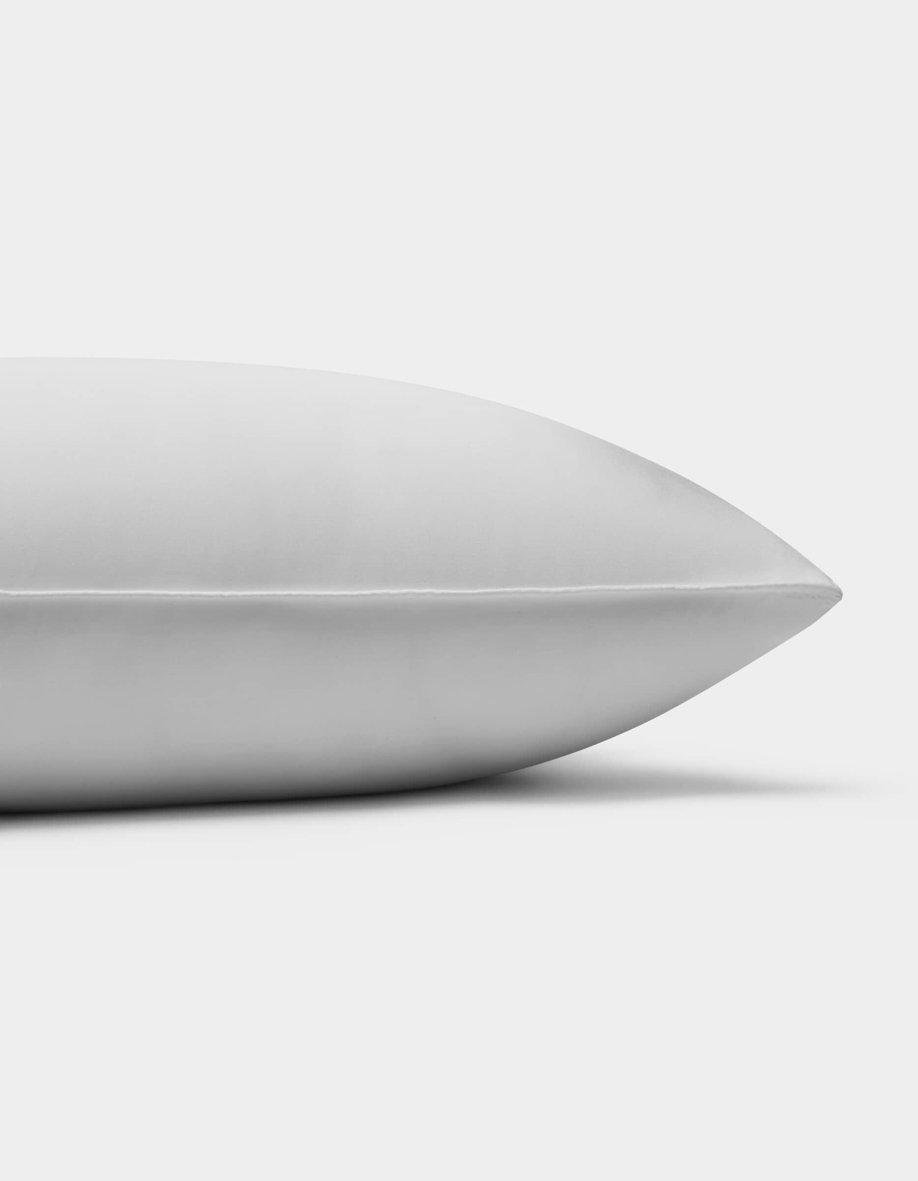 A close-up side view of the Cozy Earth Bamboo Insert Bundle pillow, featuring a smooth white surface, photographed against a plain white background.