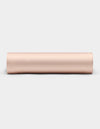 A Cozy Earth Bamboo Fitted Sheet in a light beige shade is shown rolled up on a plain white background, viewed from the side.|Color:Peony