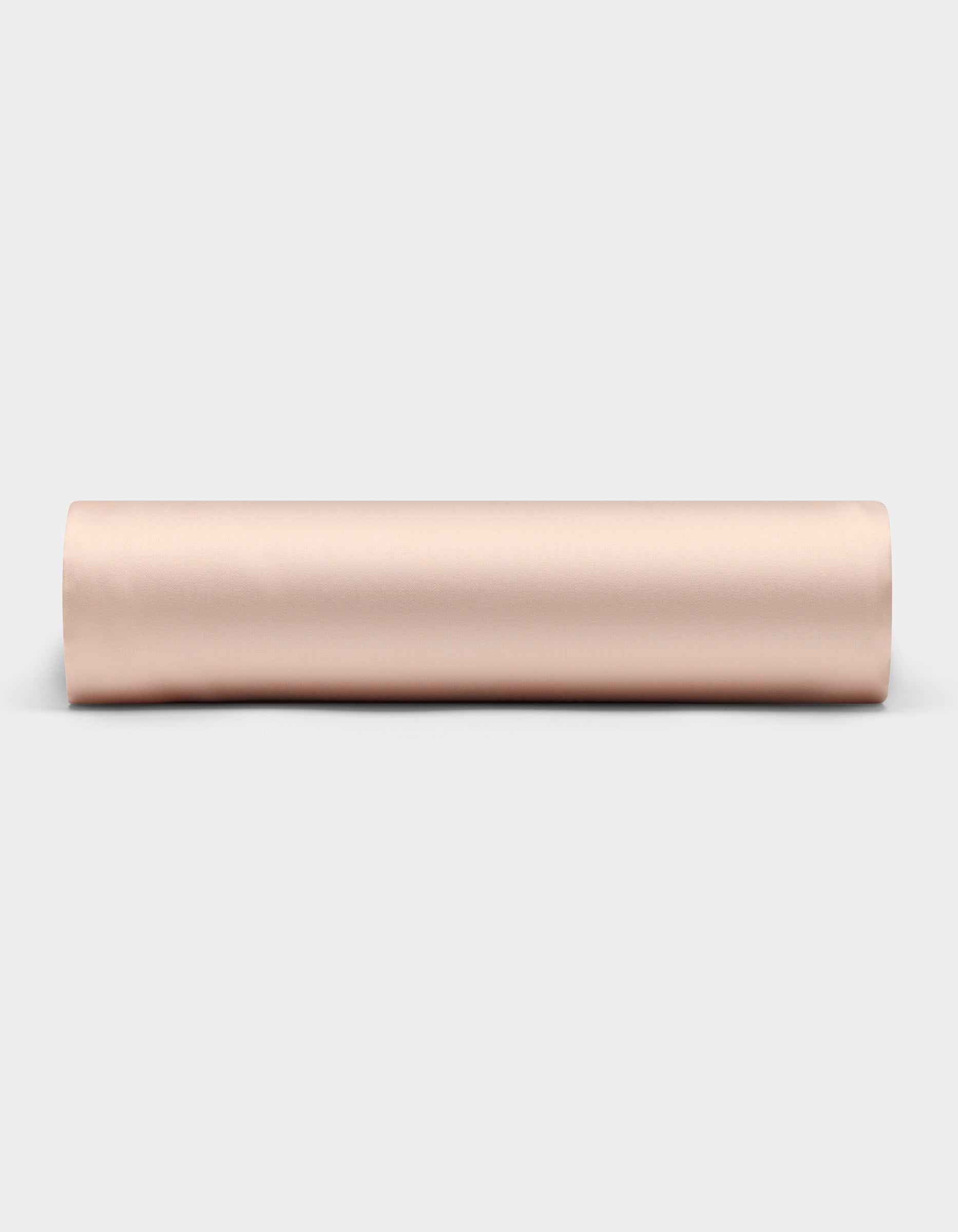 A Cozy Earth Bamboo Fitted Sheet in a light beige shade is shown rolled up on a plain white background, viewed from the side.