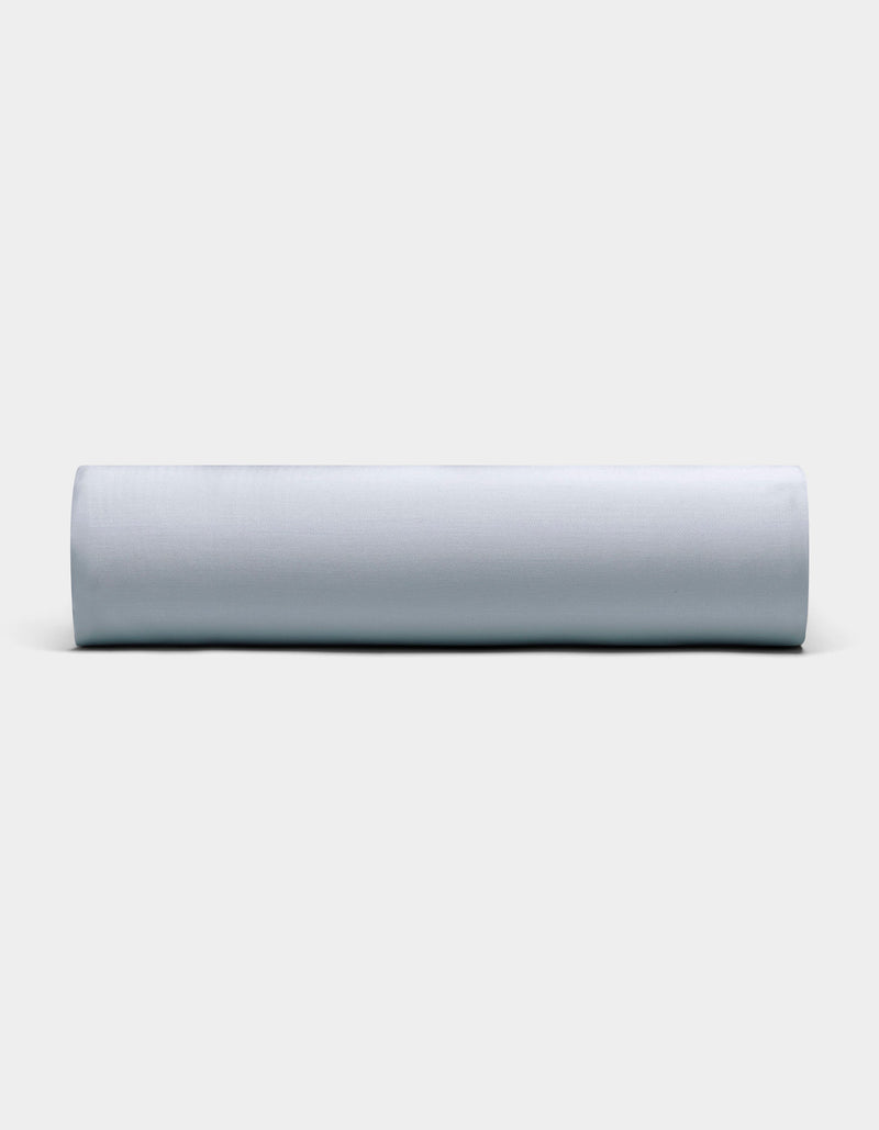 A Bamboo Fitted Sheet by Cozy Earth, neatly rolled and displayed horizontally, is showcased against a plain, light background with its soft light gray fabric visible from the front.