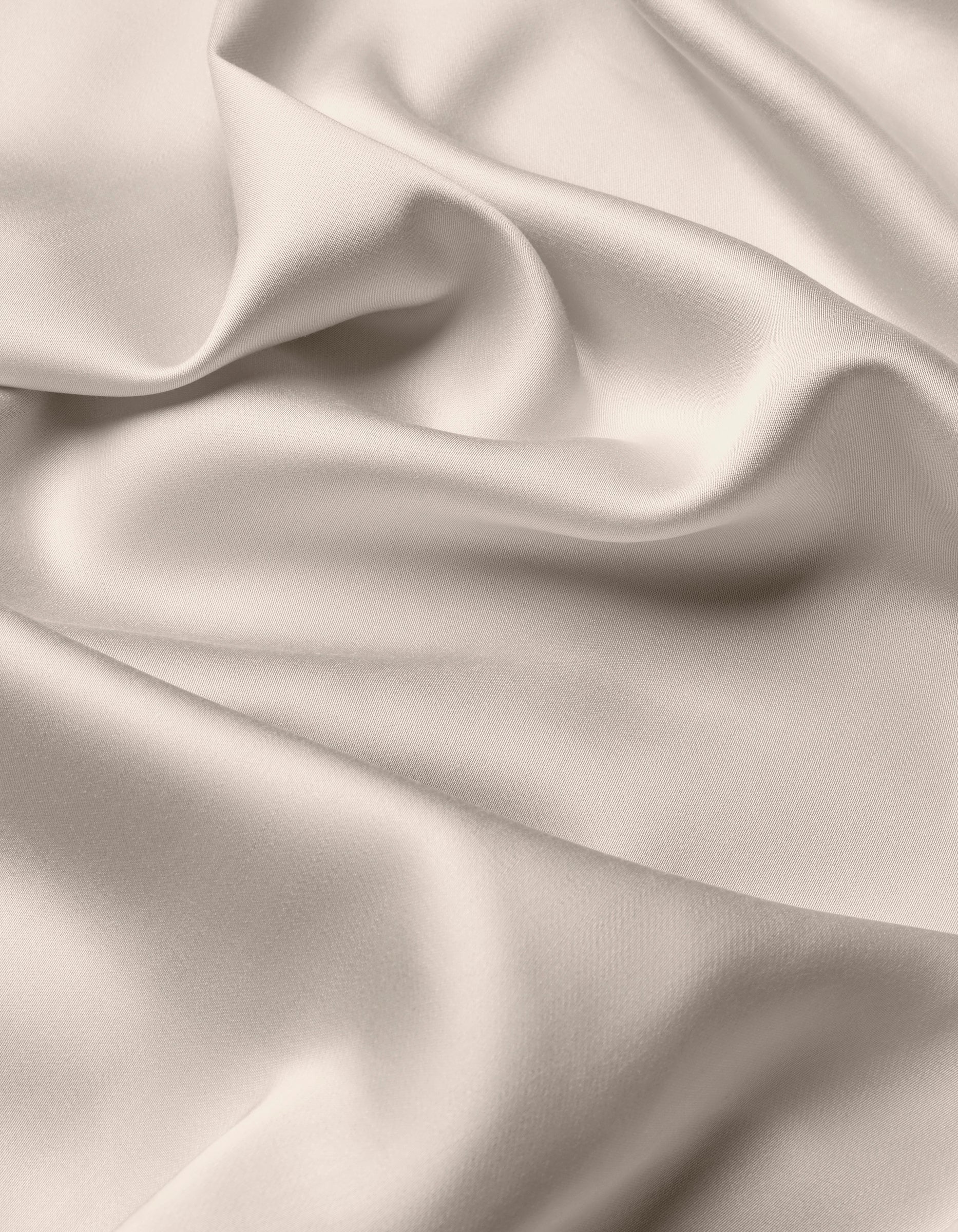 The Cozy Earth Bamboo Flat Sheet features a smooth, light-colored fabric with soft folds and gentle draping, creating a silky, elegant texture.