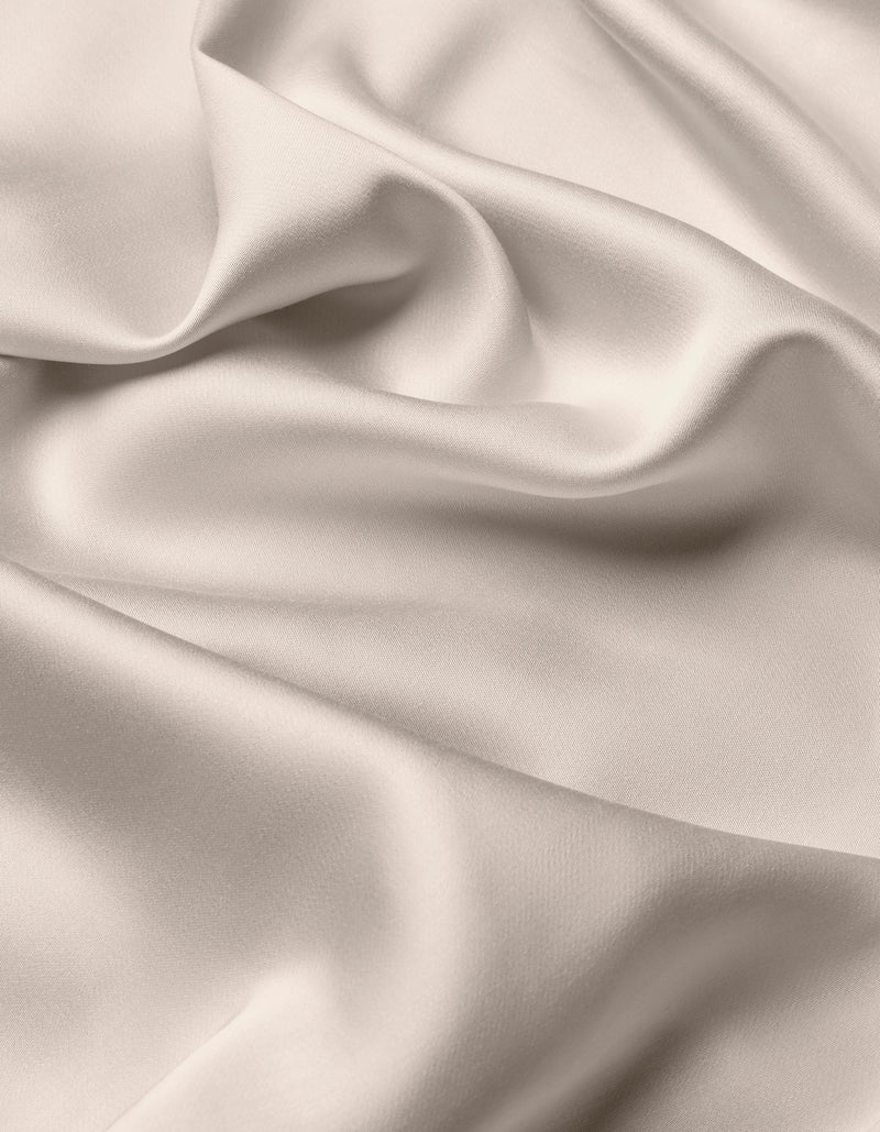 The Cozy Earth Bamboo Flat Sheet features a smooth, light-colored fabric with soft folds and gentle draping, creating a silky, elegant texture.