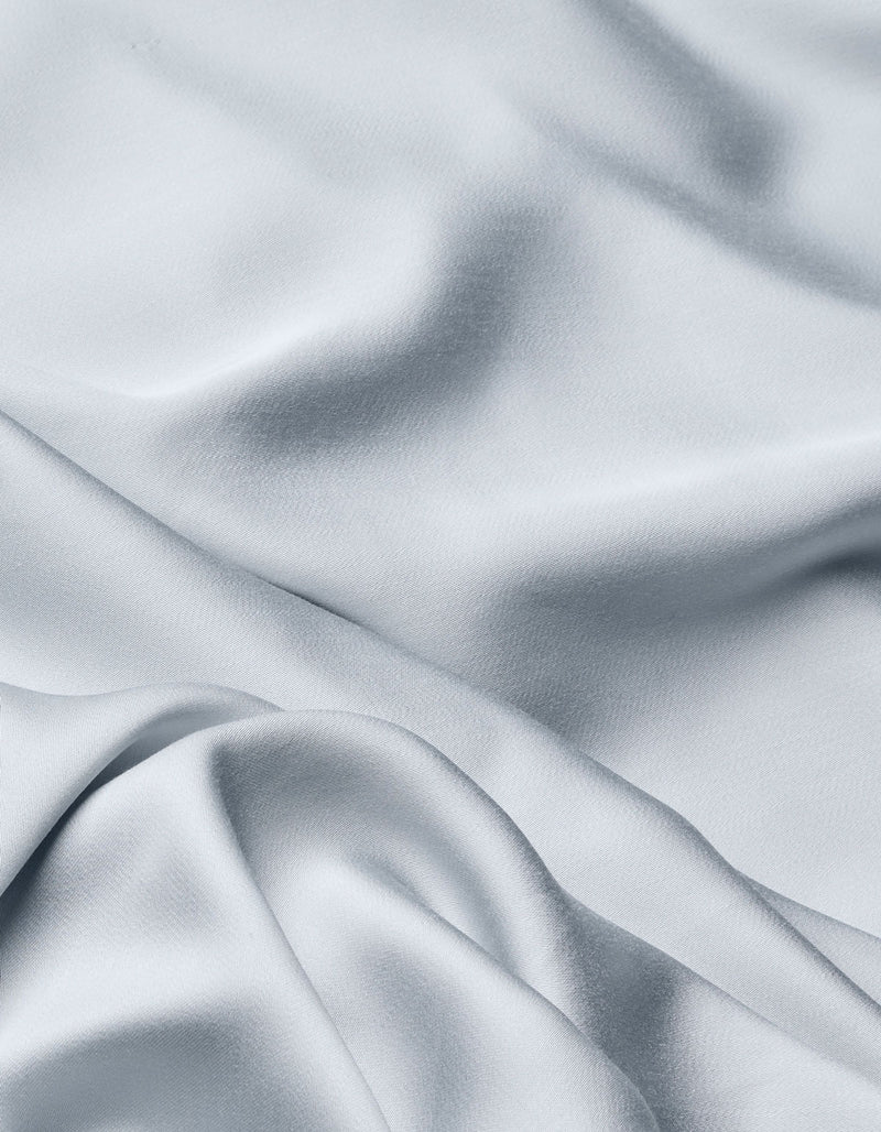 The Cozy Earth Bamboo Flat Sheet in light gray features a silky, smooth texture with soft folds and gentle shadows, adding movement and elegance to your bedding.