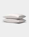 Two Cozy Earth Bamboo Pillowcases with subtle stripes are stacked together against a plain light gray background.|Color:Driftwood Pinstripe