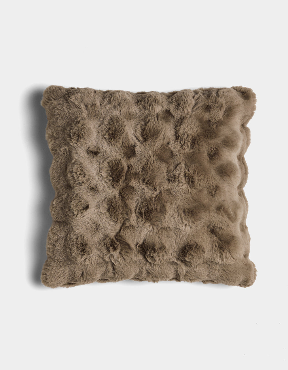 The Bubble Cuddle Pillow by Cozy Earth is a square, brown faux fur pillow with a textured, tufted surface, shown against a white background.