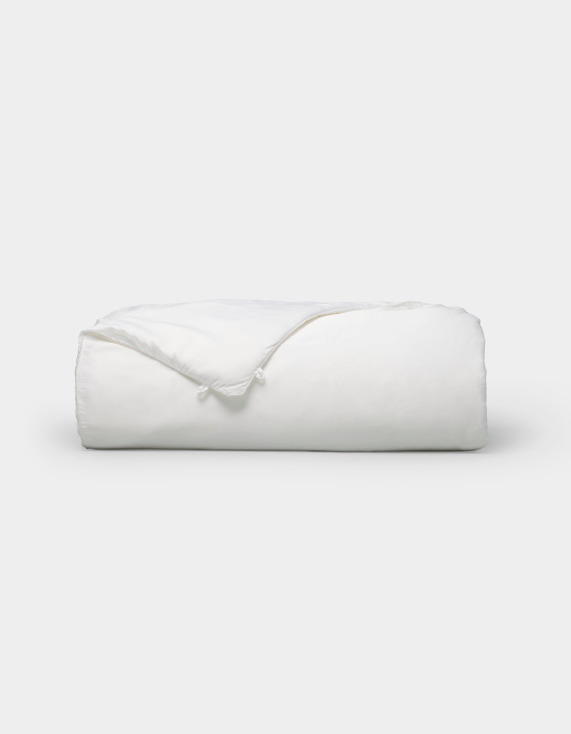 The Cozy Earth Silk Comforter is neatly folded with a corner turned down, showcased against a plain white background.|Filling:Standard
