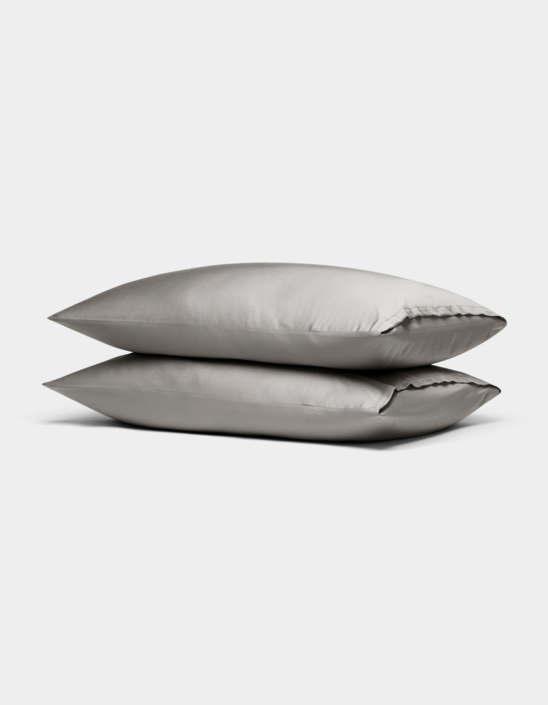 Two Cozy Earth Bamboo Pillowcases in light gray are stacked neatly on top of each other against a plain white background.