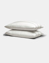 Two Cozy Earth Bamboo Pillowcases in white with subtle gray stripes are stacked on a plain light gray background.|Color:Baja Stripe in Laurel