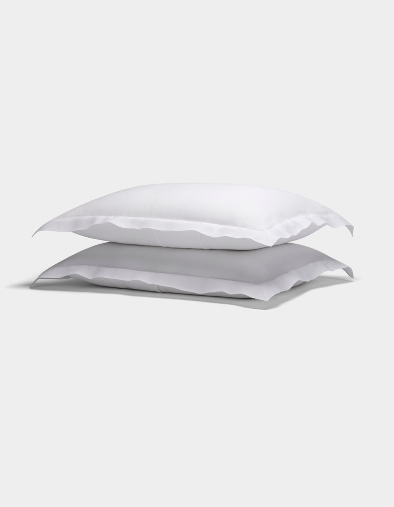 Two Cozy Earth Linen Shams with ruffled edges are stacked neatly against a plain light background.