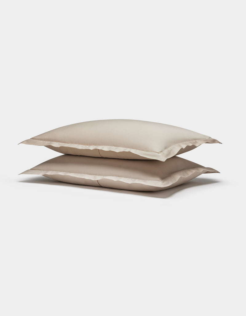 Two Soft-Wash Cotton Shams by Cozy Earth, in beige, are stacked neatly together against a plain white background.