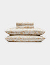 The Cozy Earth Bamboo Sheet Set includes two pillows and folded sheets with an intricate gold floral botanical pattern on a white background.|Color:Winter Toile Dijon
