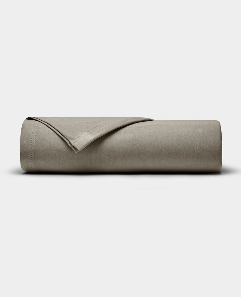The Cozy Earth Bamboo Jersey Flat Sheet, shown neatly folded in taupe, is displayed on a plain white background.