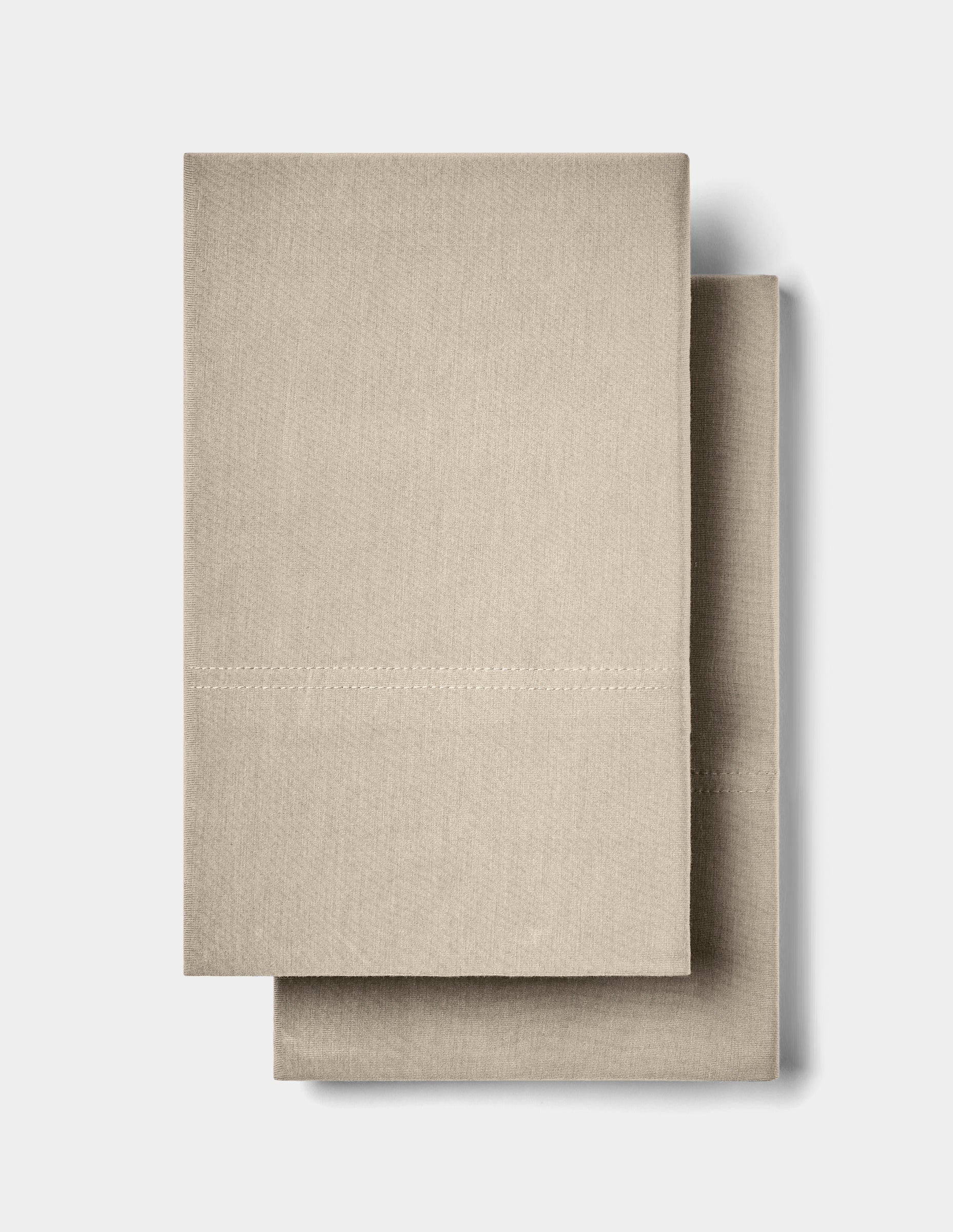 Two neatly folded Cozy Earth Bamboo Jersey Pillowcases are stacked together against a plain white background.|Color:Driftwood