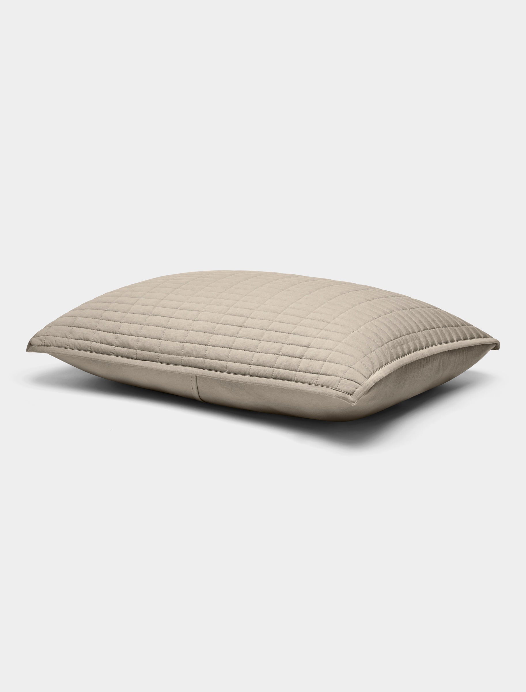 The Bamboo Jersey Quilted Shams by Cozy Earth are beige, rectangular pillows featuring a quilted pattern, displayed against a plain white background.|Color:Driftwood
