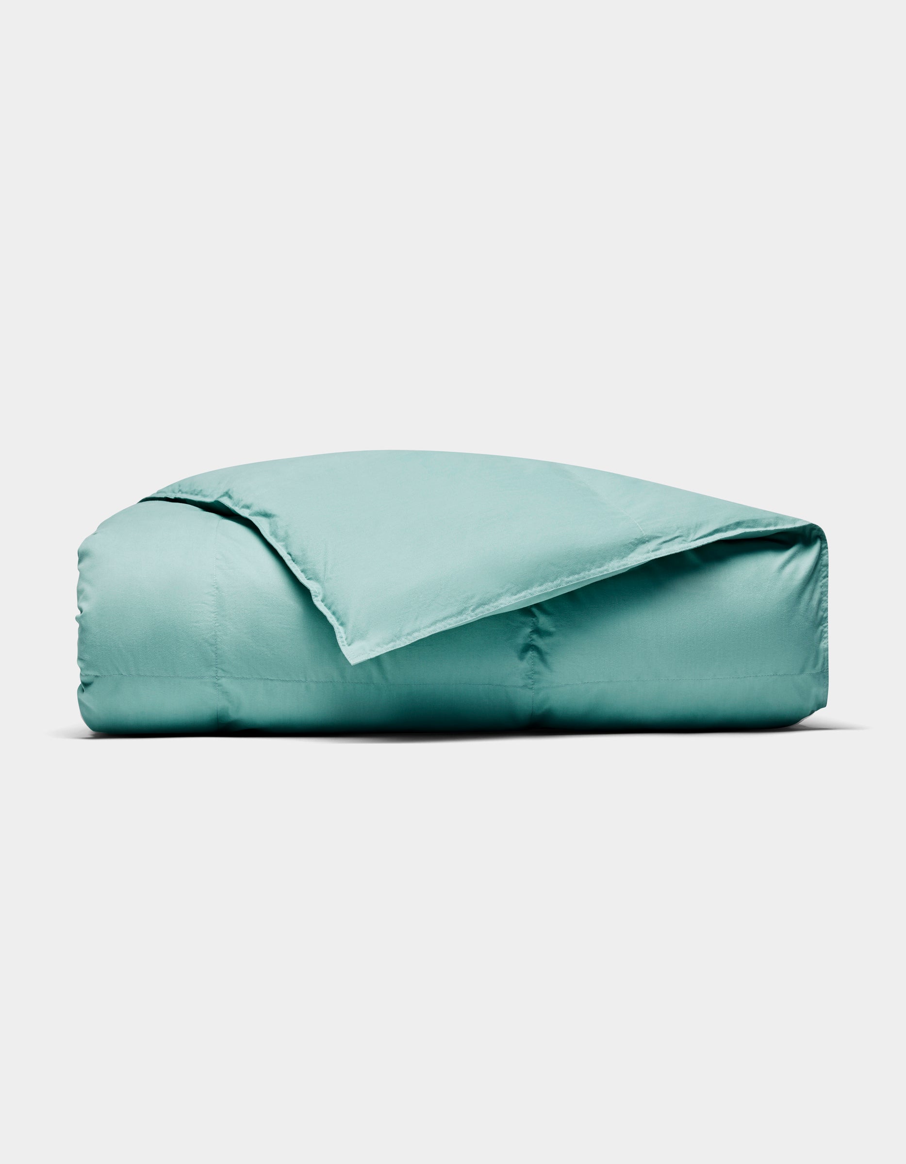 The Cozy Earth Down Alternative Throw, in light teal, is neatly folded and displayed against a plain white background.