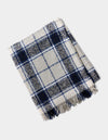 The Cozy Earth Alpaca Boucle Throw, featuring a blue, black, and white plaid design with fringed edges, is shown folded on a light background.|Color:Indigo Plaid