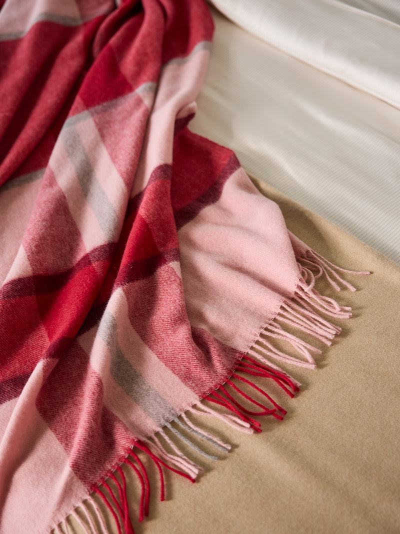Pink lucca throw laying on bed