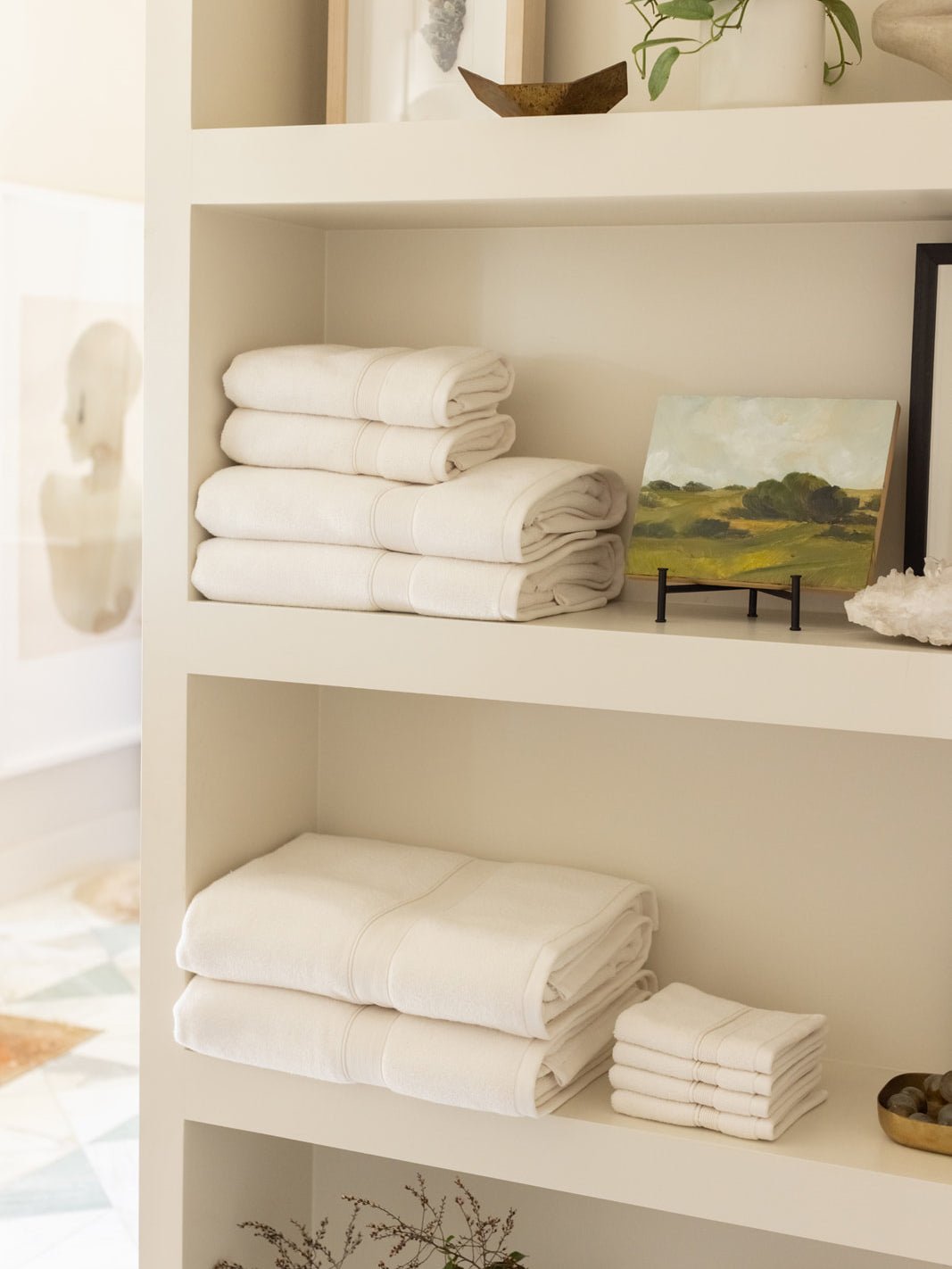 Collection of seashell luxe bath towels folded on shelves |Color:Seashell