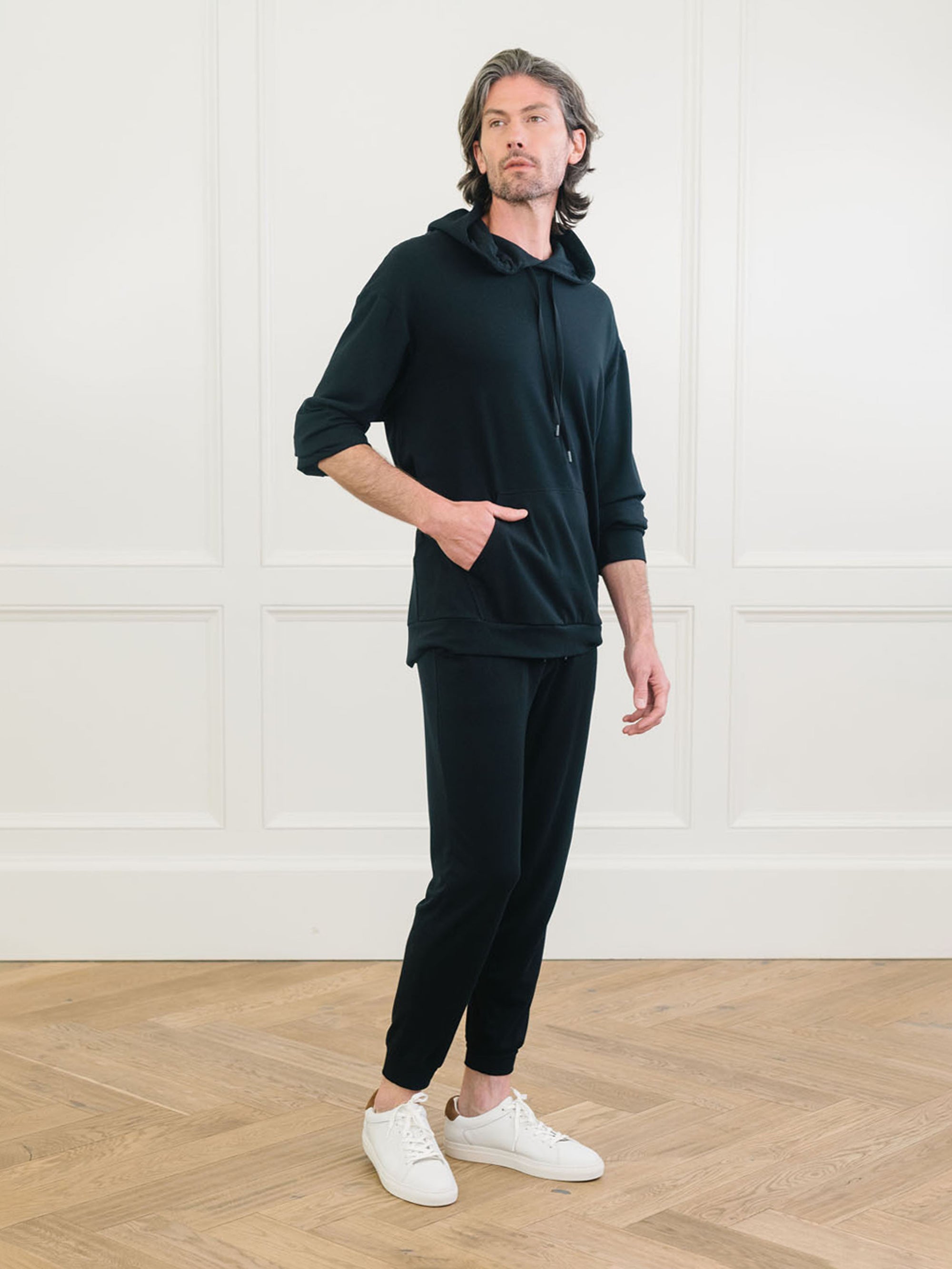 A man wears Men's Brushed Bamboo Hoodie & Jogger Set in Black. 