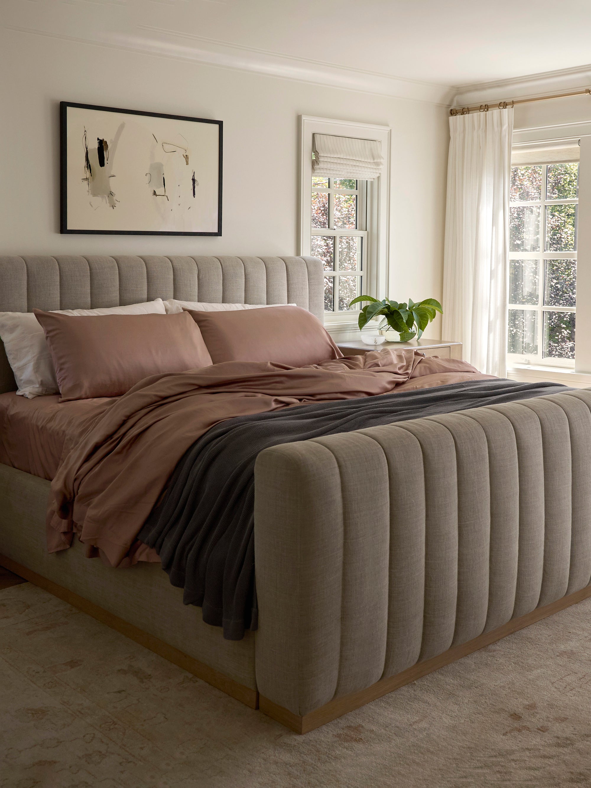Clay bedding on bed with charcoal blanket draped over it 