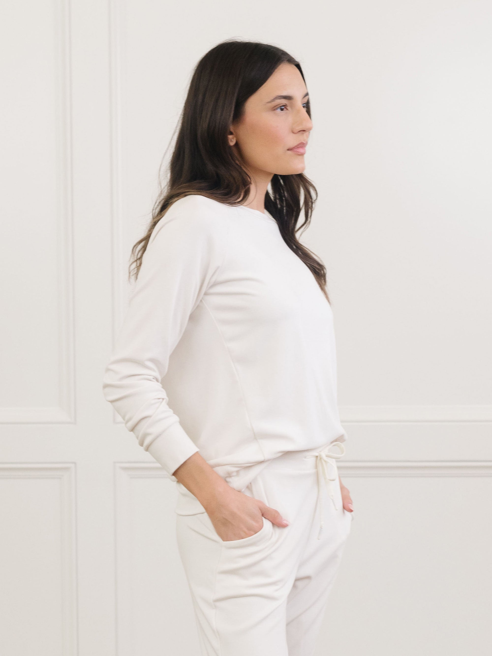 Ivory Bamboo Jogger Set modeled by a woman. The photo was taken in a high contrast setting, showing off the colors and lines of the pajamas. 