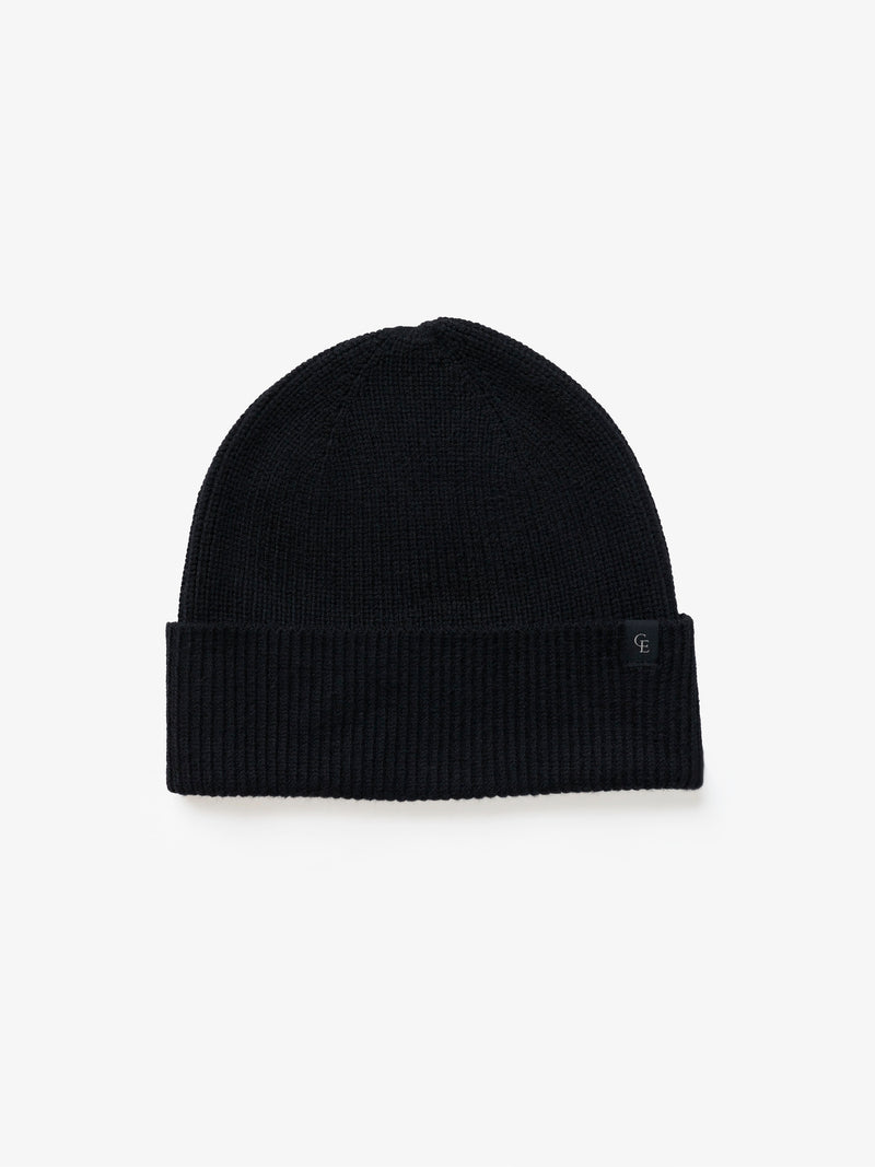 A black knit beanie on a white background
