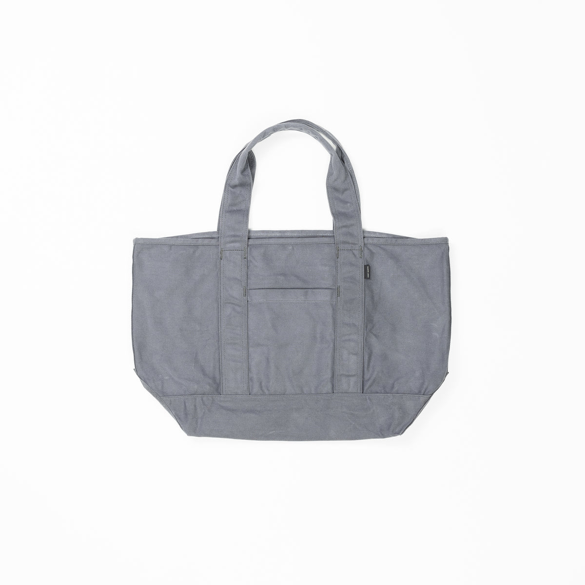 The Waxed Canvas Tote by Cozy Earth is a plain gray bag featuring double handles and a central exterior pocket. Crafted from durable fabric, it is displayed against a white background in the photograph. |Color:Washed Navy