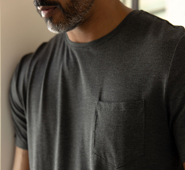 Man wearing a dark gray t-shirt with a pocket.