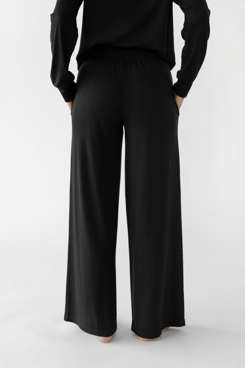 A person is wearing the Women's Ultra-Soft Bamboo Wide Leg Pull On Pant & Pullover Set by Cozy Earth, viewed from the back against a plain white background.