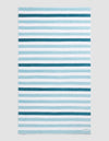 The Cozy Earth Classic Stripe Resort Towel in Lake Stripe features horizontal blue and white stripes of varying thickness and intensity, displayed flat on a neutral background.|Color:Lake Stripe