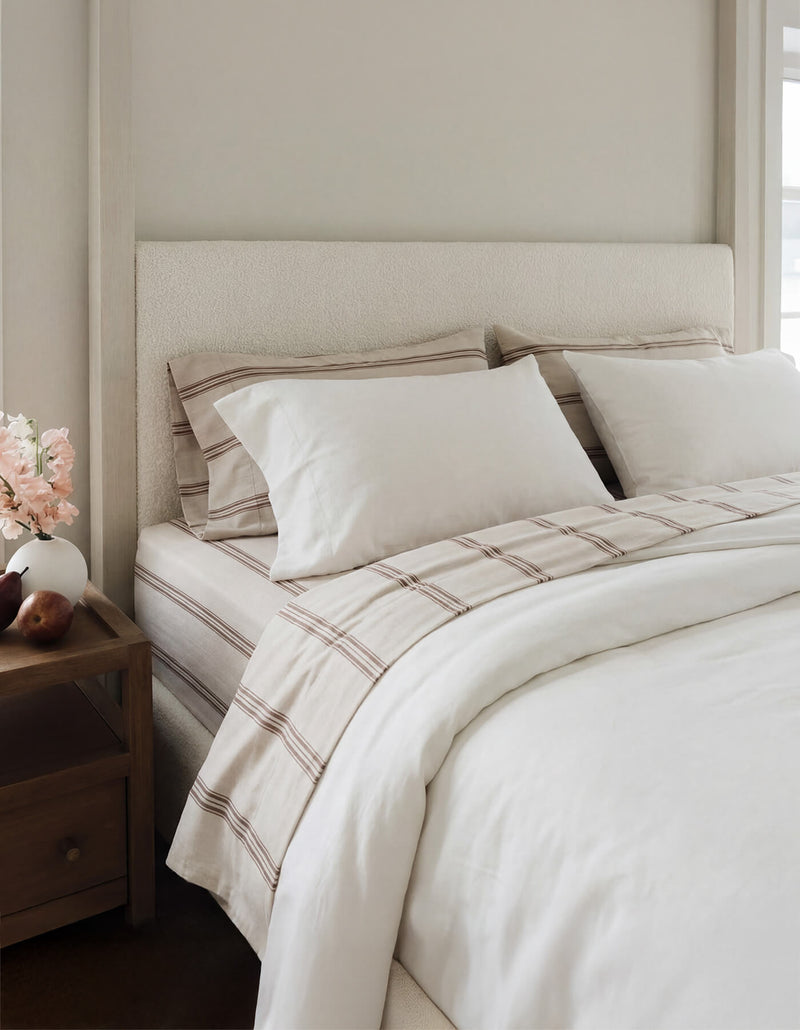 A bed featuring Cozy Earth Bamboo Sheets in Baja Stripe in Maple
