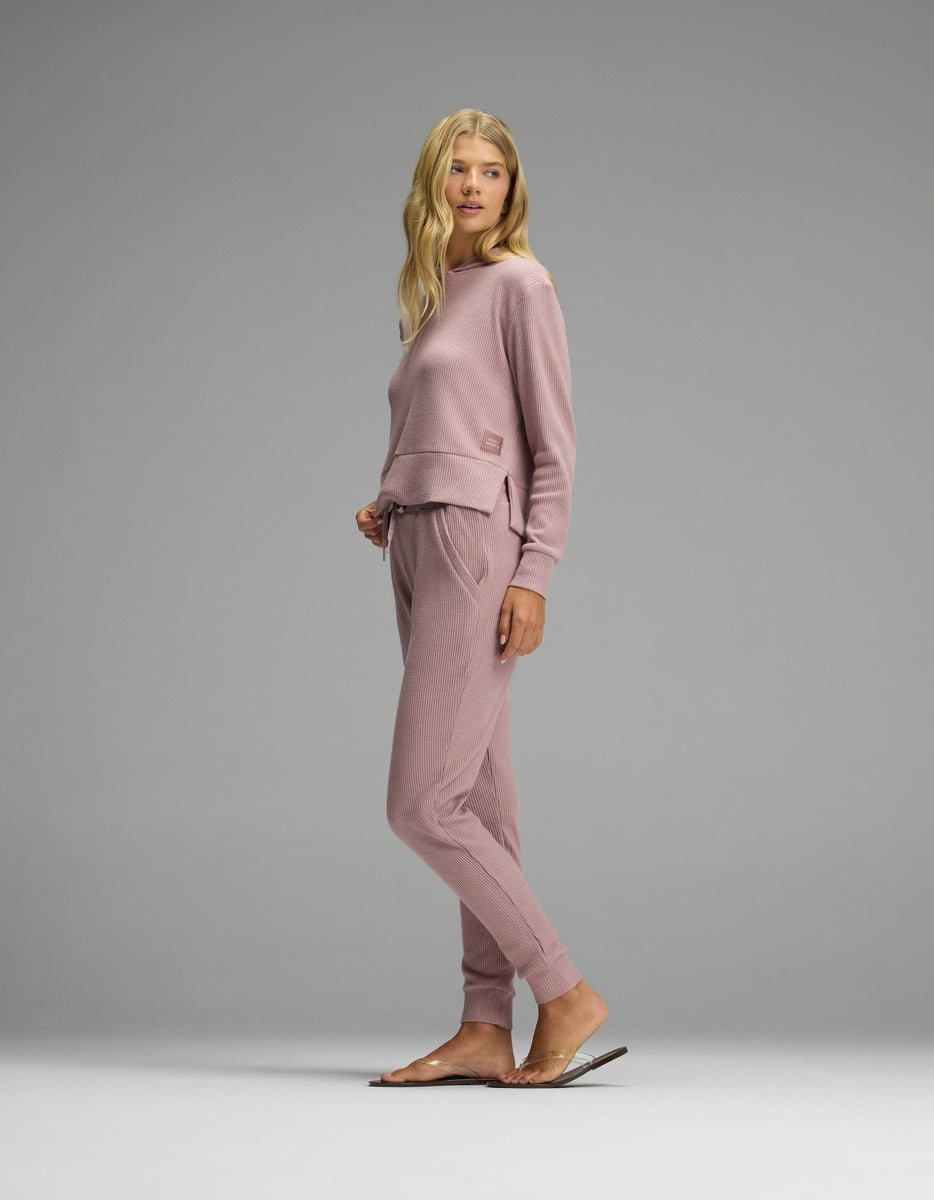 A person wearing a dusty pink Women’s Blake Waffle Hoodie & Jogger Set in a waffle-knit fabric.|Color:Viola