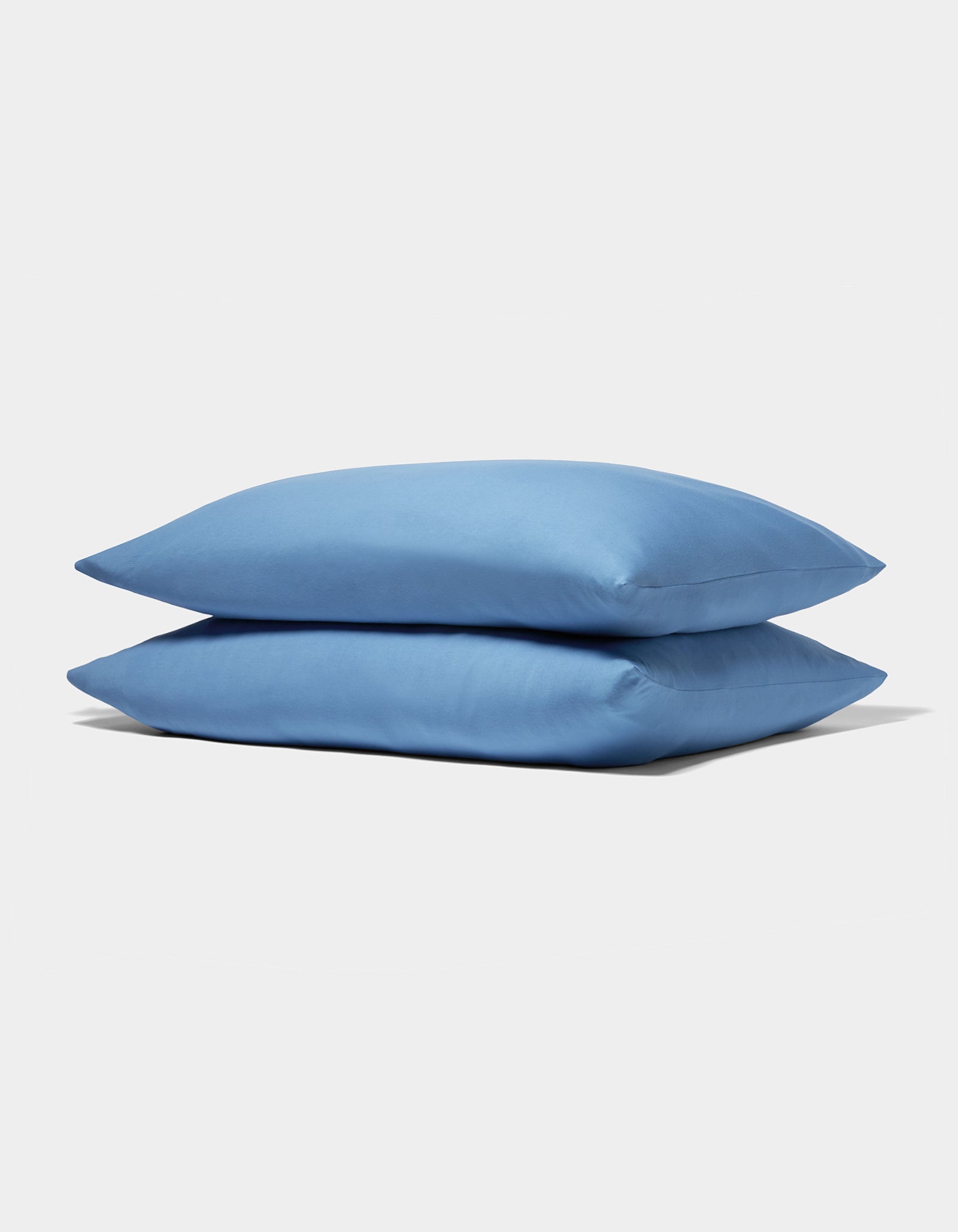 Two neatly stacked Cozy Earth Bamboo Jersey Pillowcases in light blue are displayed on a plain white background.