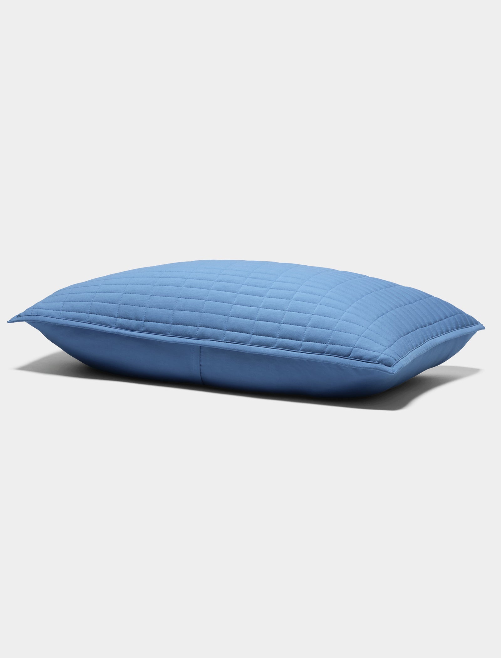 The Bamboo Jersey Quilted Sham by Cozy Earth is a blue, rectangular pillow with a quilted pattern, displayed on a plain white background.|Color:Sailor